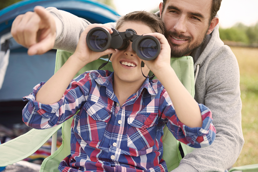 Father and son using binoculars in nature