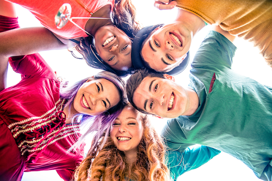 Group of teens huddled together and smiling